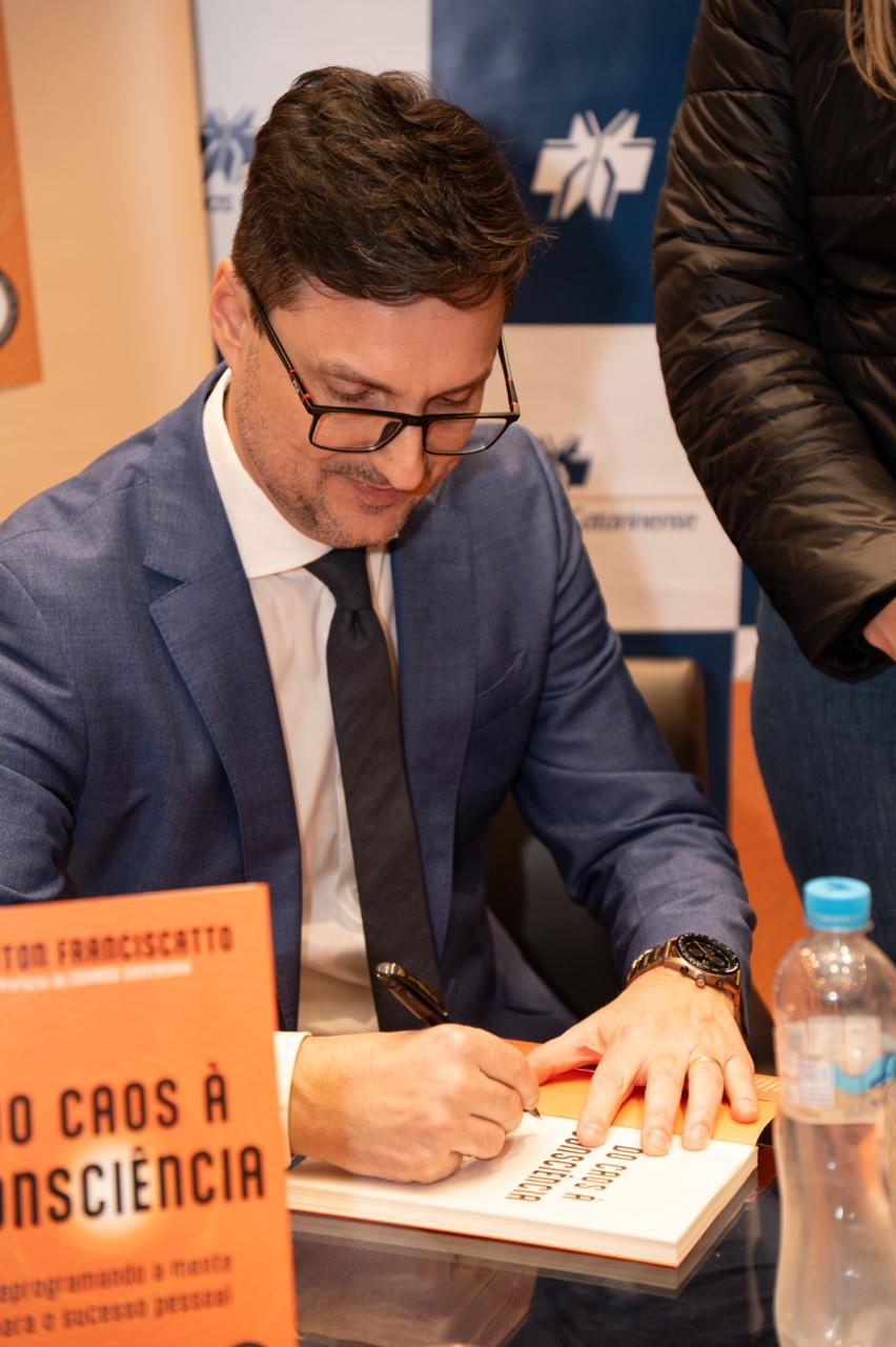 Kleiton Franciscatto autografando o livro Do Caos à Consciência em um evento